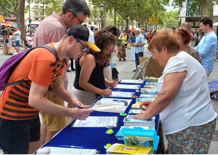 Image for article Барселона, Испания. Во время мероприятия практикующих Фалунь Дафа люди подписывали петицию, призывающую прекратить преследование в Китае